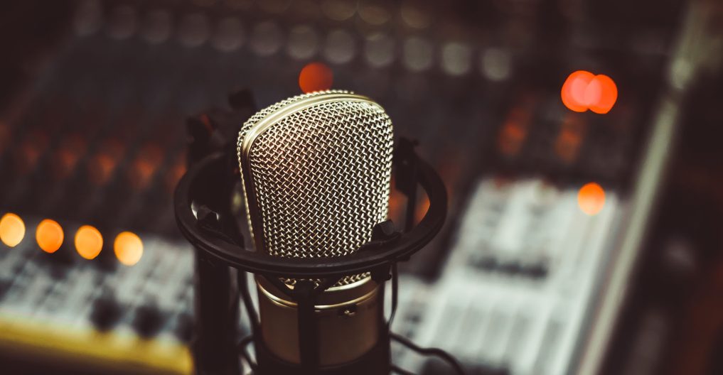 microphone and mixing console Professional condenser studio microphone over the musician blurred background and audio mixer, Musical instrument Concept.